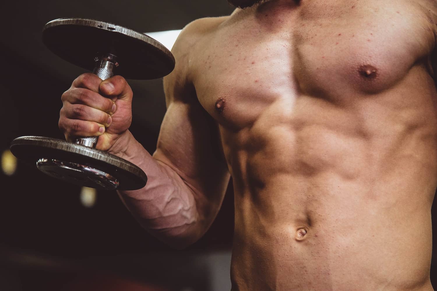 man with abs lifting a weight