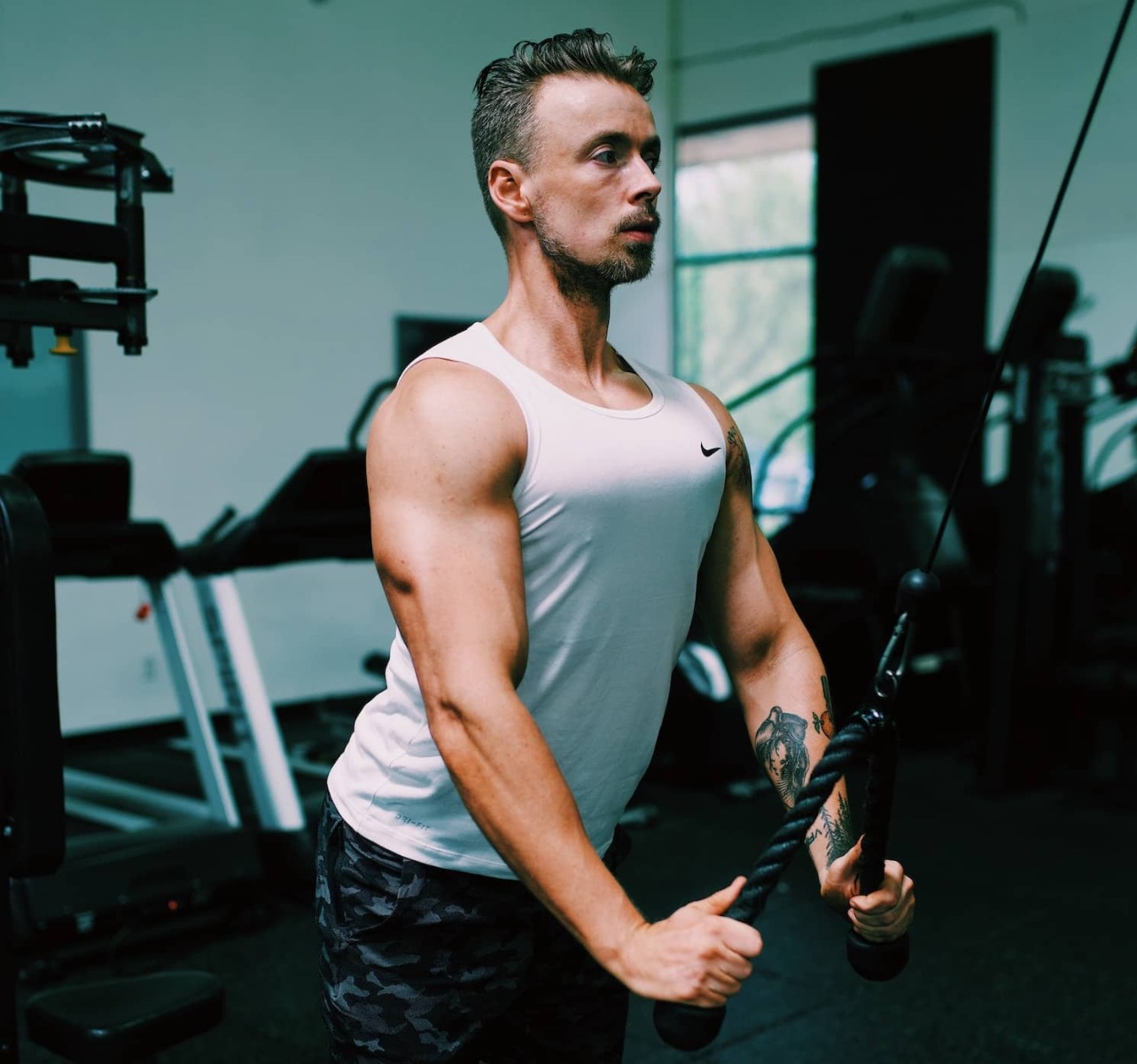 A man in a gym doing a face pull exercise 